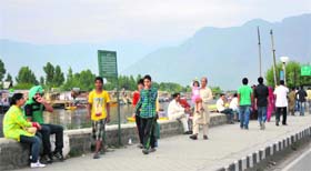 Visitors take a walk along the banks of the Dal Lake in Srinagar