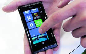 A salesman demonstrates a Nokia smartphone in a shop in Riga. Nokia shares, which have lost around 80% since Feb 2011 when the firm decided to drop its own smartphone software in favour of the largely untried Windows OS, were up 10% after the Q2 results.