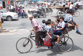 Throwing caution and safety to the wind, a rickshawpuller ferries no less than ten students adjusted on his modified vehicle in Bathinda on Thursday