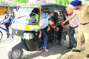 An STA official counts the occupants in an autorickshaw during a challan drive at Sector 40 in Chandigarh on Thursday.