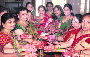 Women participate in a mehndi competition at a Teej function in Dehradun on Thursday. 