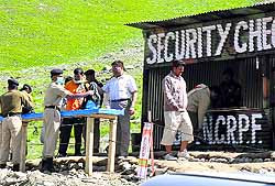Security personnel check the luggage of pilgrims at the entrance of the yatra base camp in Baltal
