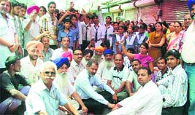 Students and residents stage a protest against the setting up of a liquor vend near a school in Ludhiana on Thursday