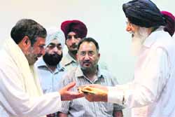 Punjab Chief Minister Parkash Singh Badal presents a sword to Union Commerce Minister Anand Sharma in Chandigarh on Thursday. A Tribune photograph