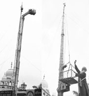 A rescue operation under way to bring down sewadar Joginder Singh, who was stuck atop a pole at Gurdwara Akal Ashram in Sohana, Mohali, on Friday; and Joginder alights from a hydraulic ladder.