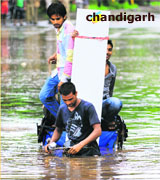 A rickshaw-puller wades through a water-logged road in Industrial Area, Phase I, Chandigarh.