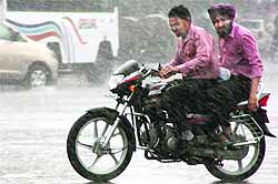 Two youngsters ride a bike amid morning hour showers in Ludhiana on Friday