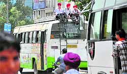 Students risk their lives by sitting on the roof of a bus in Ludhiana on Friday