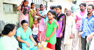 Health Department officials distribute medicines among residents of Badunagar Colony in Patiala. 