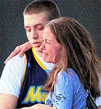 Jacob Stevens (18) hugs his mother Tammi outside Gateway High School, where witnesses of the attack were brought for questioning