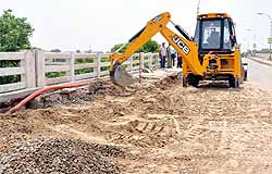 PWDs JCB machines fill the holes with mud as a temporary measure. Repair and restoration work on the overbridge is expected to begin on Sunday