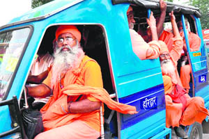 Sadhus travel in a packed auto-rickshaw during a religious function in Haridwar. 