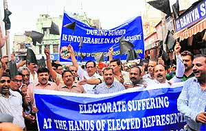 Members of the Jammu Chamber of Commerce and Industry protest against unscheduled power cuts in Jammu on Saturday