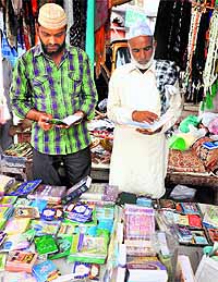 Devotees read a holy book as they observe fast during the first day of Ramadan in Jammu on Saturday