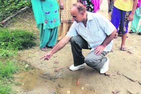 Residents of the Carol Bagh area in Jalandhar show a water-clogged road after light rain in the area.