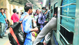 A passenger tries to board the Indore-Jammu Tawi Express through the emergency exit at the Ludhiana railway station.