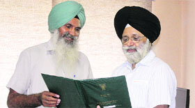 Gurcharan Singh Mann (left) shows the NG Ranga Farmer Award 2011 to PAU Vice-Chancellor Baldev Singh Dhillon.