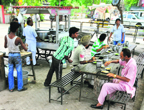 Customers relish a meal at a road-side eatery in Jalandhar.