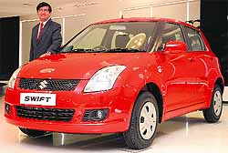 Maruti Suzuki Indias Chief Operating Officer (Marketing and Sales) Mayank Pareek poses with a Swift car