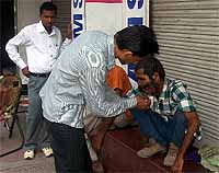 Volunteers of the Sahara Jan Seva attend to a patient with a festering wound in Bathinda