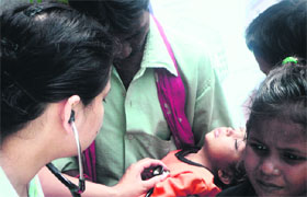 A doctor examines a child at a health camp in Dehradun on Sunday.