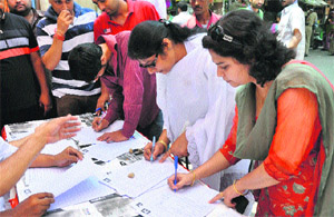 Youth take part in a signature campaign at Purani Mandi Chowk in Jammu on Sunday. 