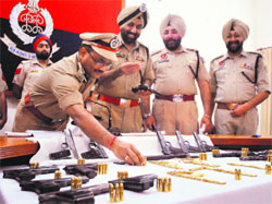 IGP Paramjit Singh Gill, DIG LK Yadav and SSP Gurpreet Singh Gill with seized arms and ammunition in Patiala on Sunday.