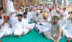 Congress workers stage a dharna near the Mansa flyover on Monday demanding rollback of the hike in power tariff. The party also protested against the cess being levied on sugar by the state government.