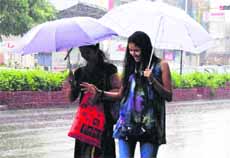 Two girls seem to be enjoying the rain in Dehradun on Monday.