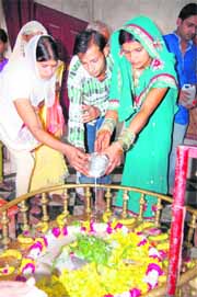 Devotees offer Ganga Jal and milk to a Shivalingam at Daksh Prajapati Mahadev temple in Haridwar on Monday.