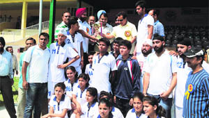 Players of the winning team with the  trophy at Bakshi Stadium in Srinagar. 