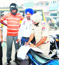 A traffic police official issues challan to a violator in Amritsar on Tuesday. 