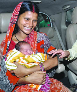 Juli Devi, the 27-year-old woman who on Sunday gave birth to a baby girl on a Metro train, poses with the newborn after being discharged from RML Hospital in New Delhi on Tuesday. 