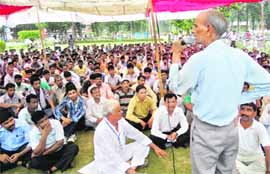 A union leader addresses the contractual employees in Kurukshetra University on Tuesday.