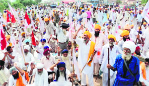 Farmers hold a protest on the GT Road near Umranangal village.
