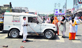Women block a road in protest against shortage of water and electricity in the Batamaloo area of Srinagar on Tuesday.
