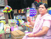A woman uses a hand-held fan during a power cut at the Warehouse market in Jammu on Tuesday. 