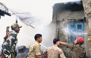 Fire-fighters douse a fire in a house in Kokrajhar.
