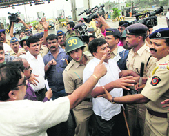 Policemen try to stop MNS workers from vandalising toll booths in Mumbai on Tuesday