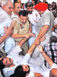 Congress workers being pulled away by policemen following a clash in Jalandhar on Tuesday