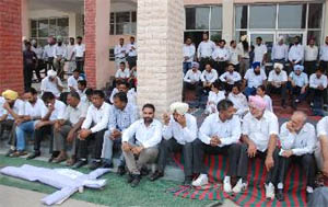 Lawyers sit outside the district and sessions court during the strike, called to protest against the setting up of the evening court, in Bathinda on Wednesday. 