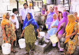 Residents of Maloya village queue up to fill their buckets with water on Wednesday