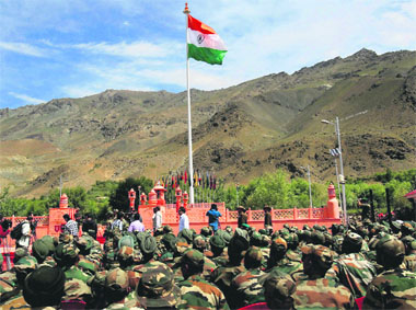 Army soldiers at the Kargil War Memorial during the celebrations of Vijay Divas in Drass on Wednesday. (Below) Actor Neha Dhupia is all smiles at the function; an Army daredevil jumps through a ring of fire. 