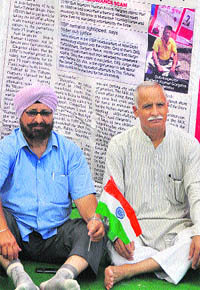 Members of the Jammu Province People Forum sit on a dharna outside the Exhibition Ground in Jammu on Wednesday. 