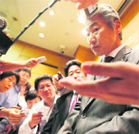 Nomura Holdings Inc incoming CEO Koji Nagai (C) is surrounded by reporters after a news conference in Tokyo on Thursday. Nomura named Nagai as its new CEO on Thursday and said it was likely more insider trading cases would come to light in a scandal that forced Kenichi Watanabe to quit as head of Japan's top investment bank