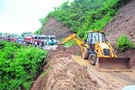 An earth mover clears a road blocked by a landslip in Sakoh near Dharamsala on Thursday