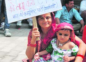 A CPM activist, along with her child, participates in a demonstration in Hamirpur on Thursday