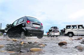 Motorists have a hard time negotiating gravelly patches exposed by the overnight rain in Jammu on Thursday