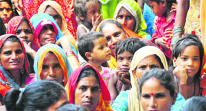 Migrant workers sit in protest outside the Sarabha Nagar police station in Ludhiana on Thursday.