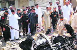 Security officials inspect the site of a bomb explosion in Salarzai, Bajaur district, on Thursday. 